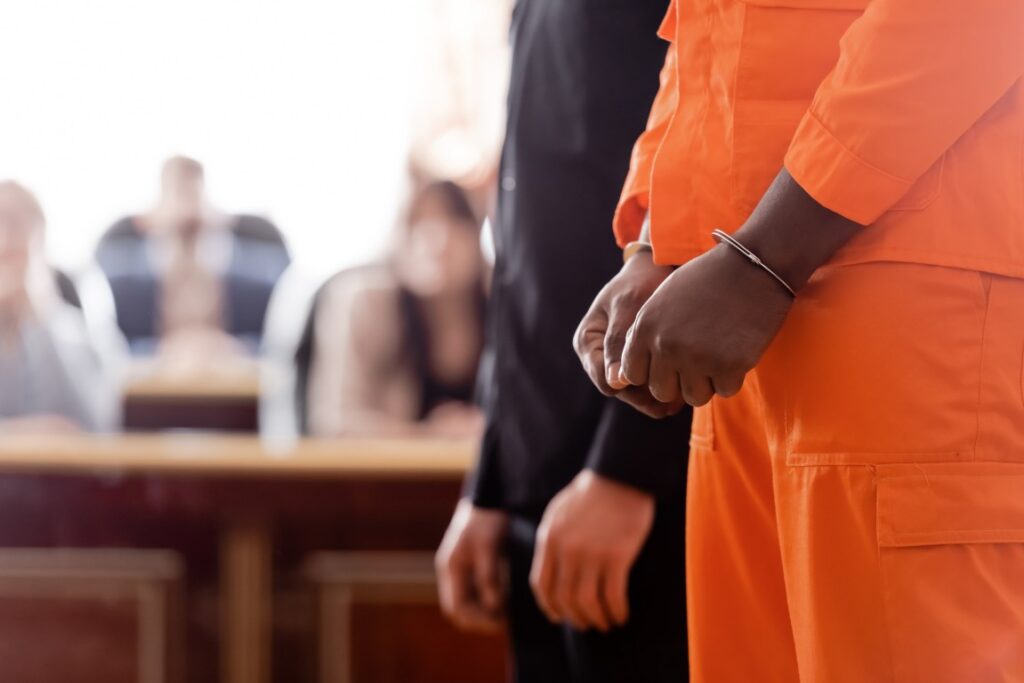 A defendant and lawyer standing together in a courtroom
