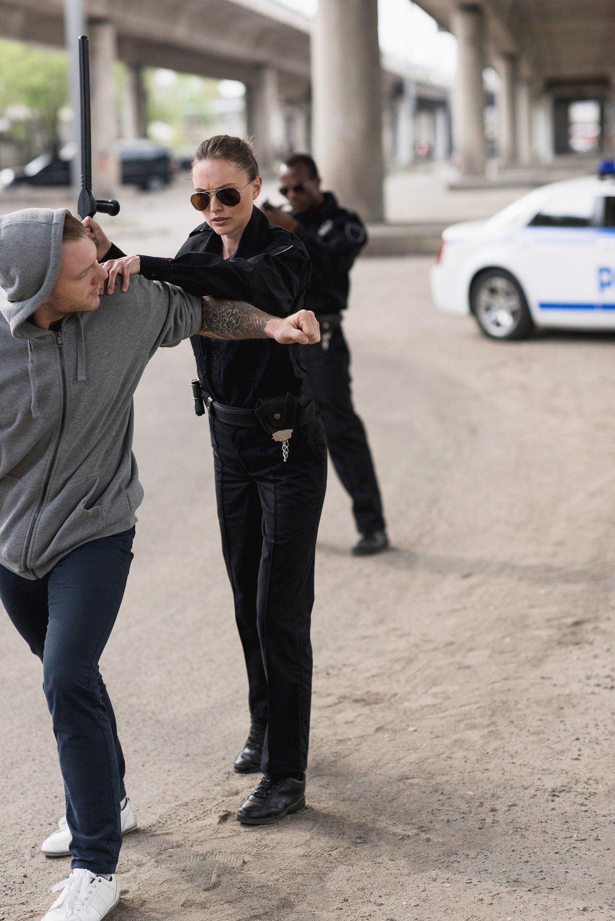 A police officer putting a man under arrest.