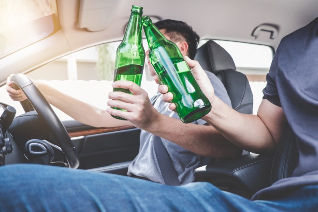 A driver and passenger drinking alcohol in a moving vehicle