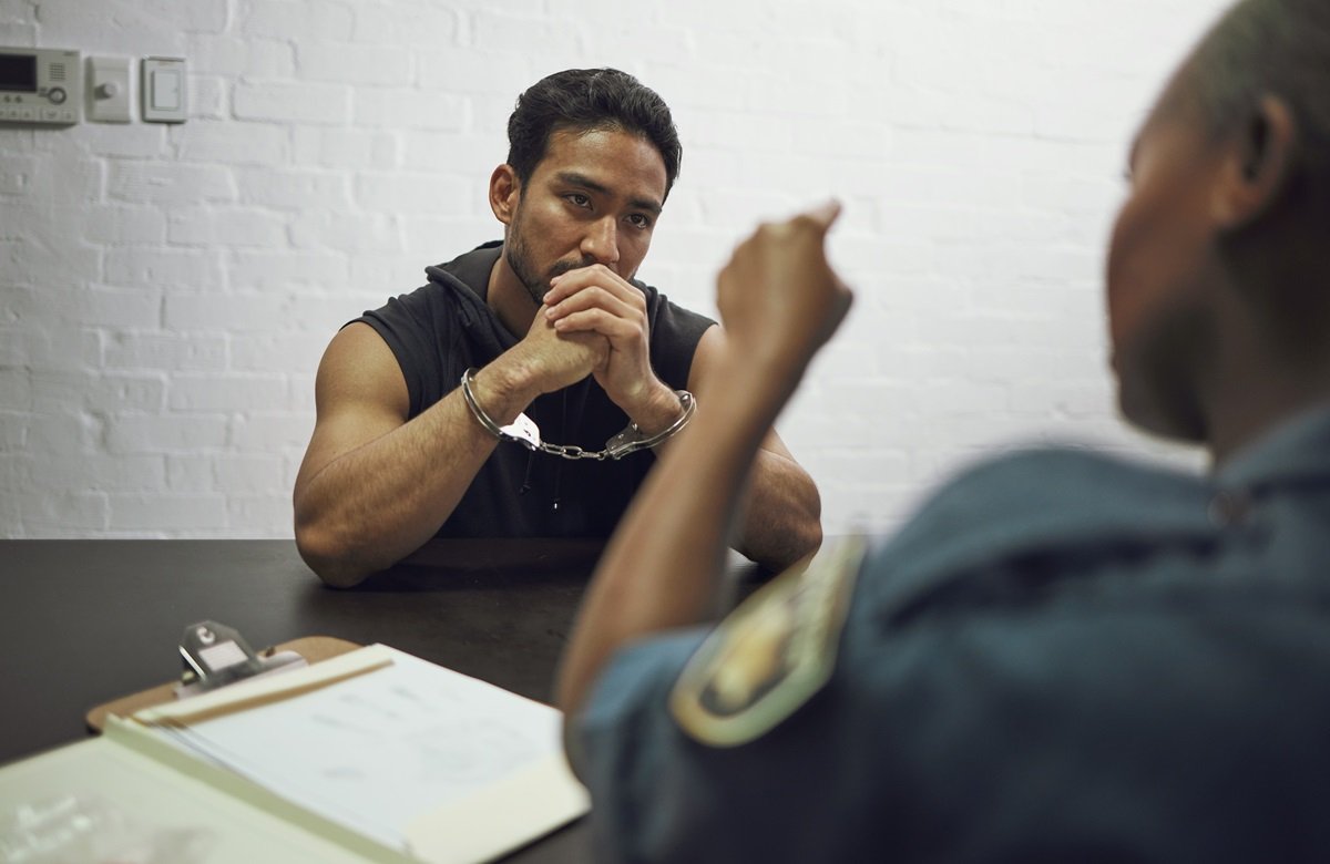 A guard putting handcuffs on a prisoner in jail