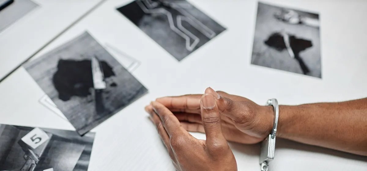 A close-up of a man's hands in handcuffs surrounded by crime scene images