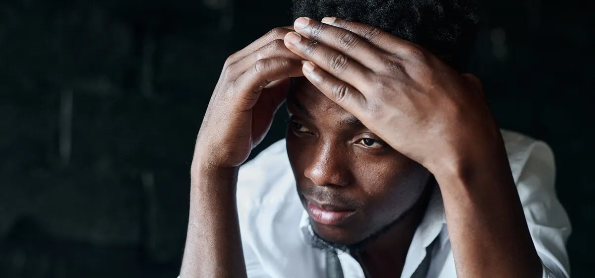 An unhappy man with his head in his hands
