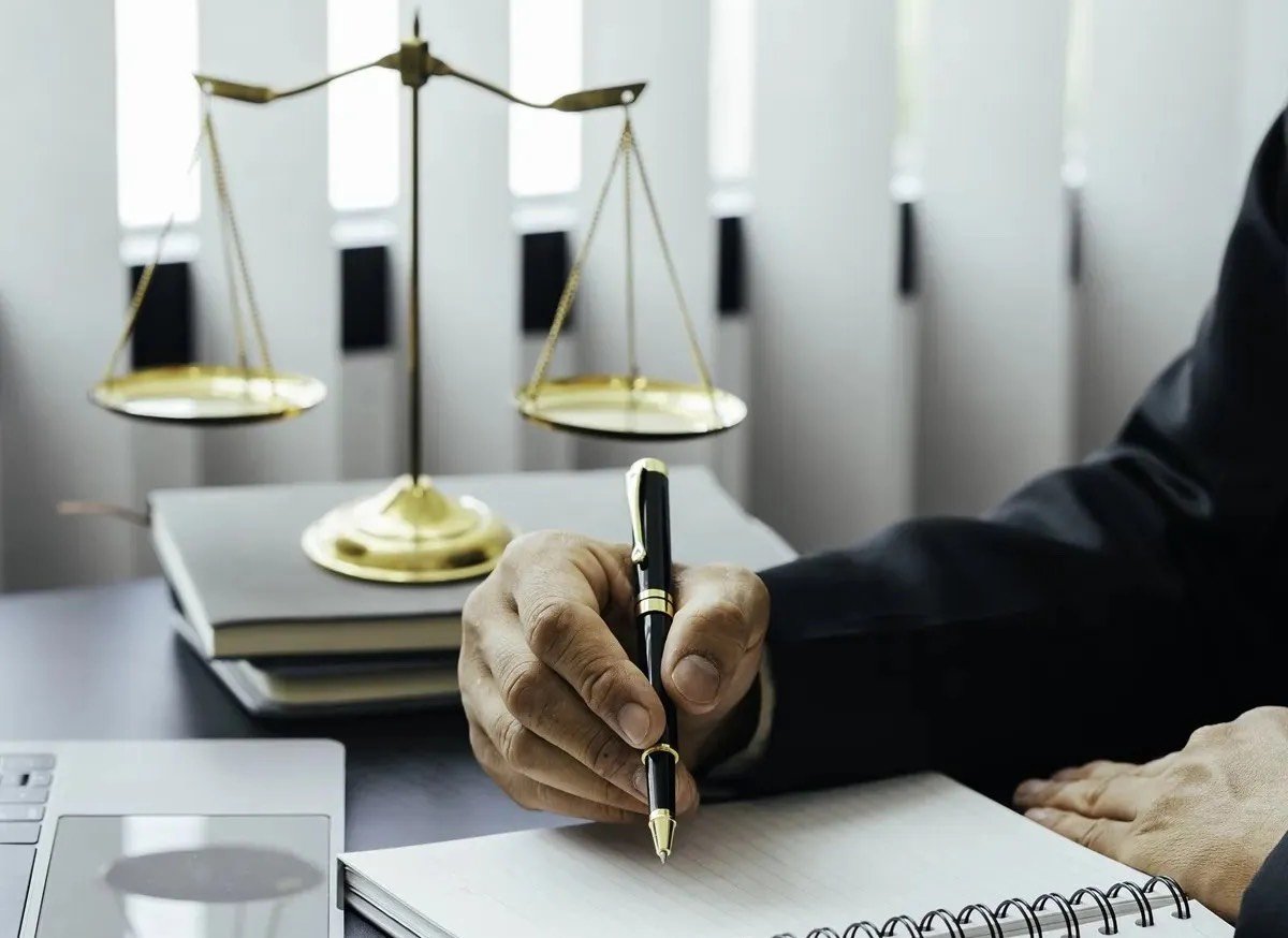 An attorney working at a desk with a scale and gavel