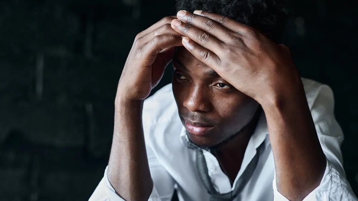 An unhappy man with his head in his hands