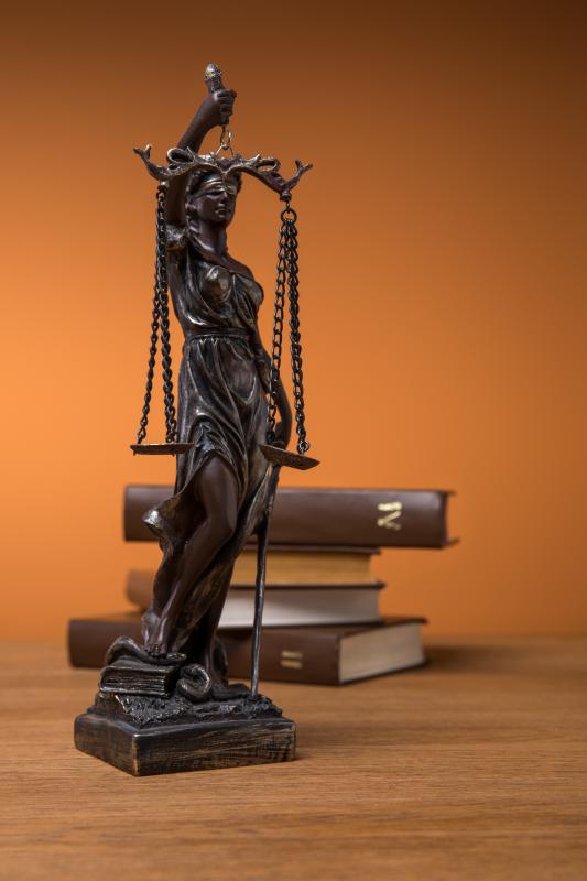 A statuette of Lady Justice in front of an open book