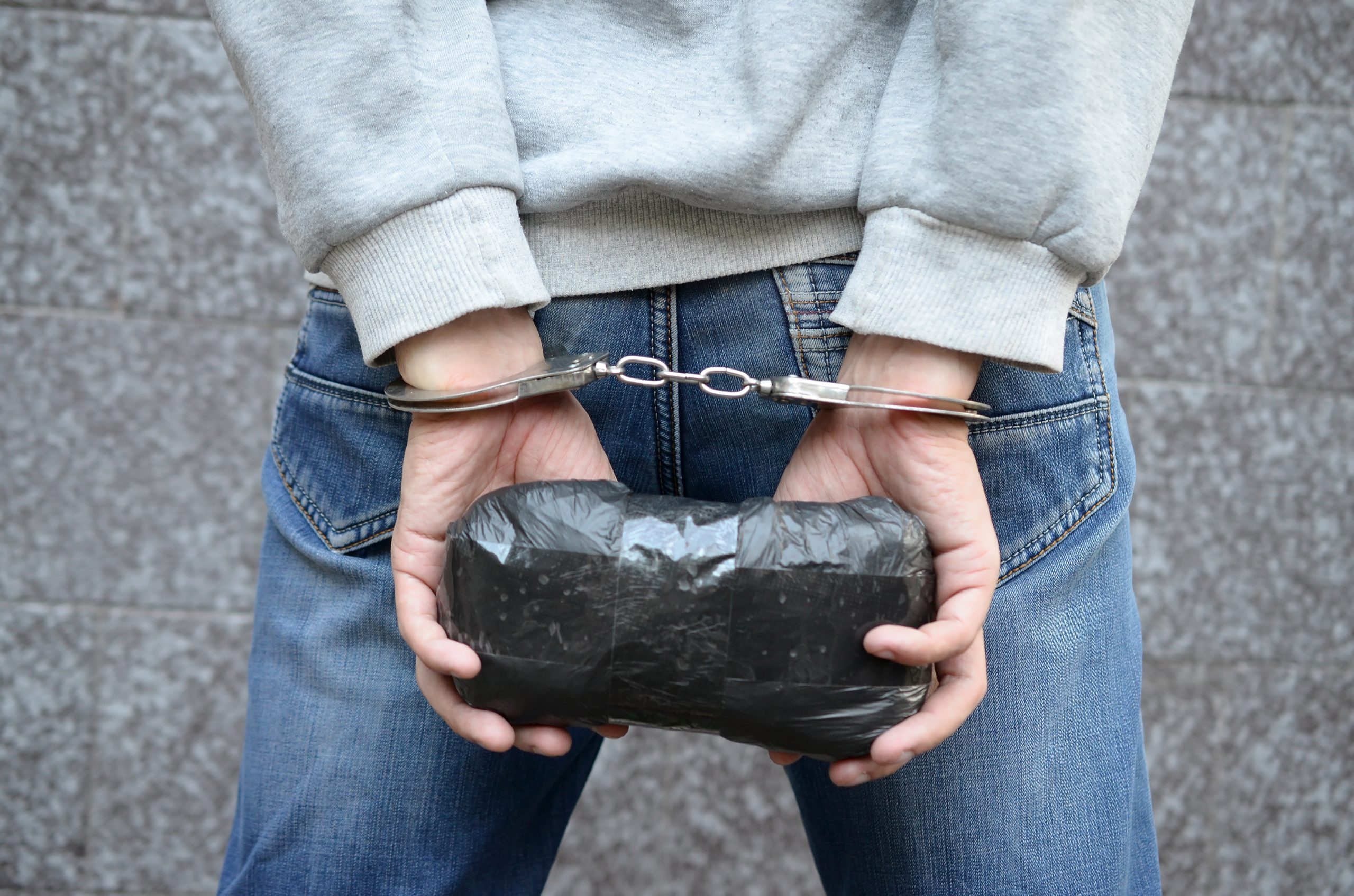 A drug dealer arrested and put in handcuffs
