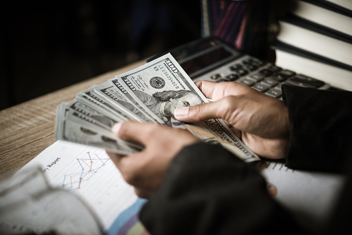 A man holding a fanned stack of money
