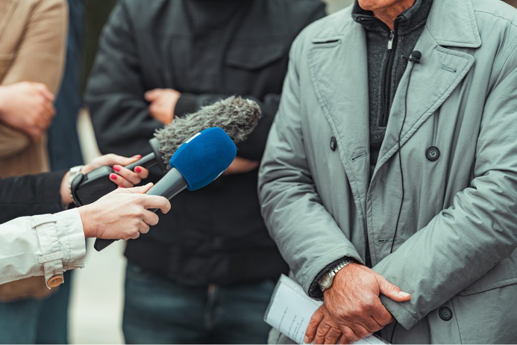 Reporters interviewing a man outside