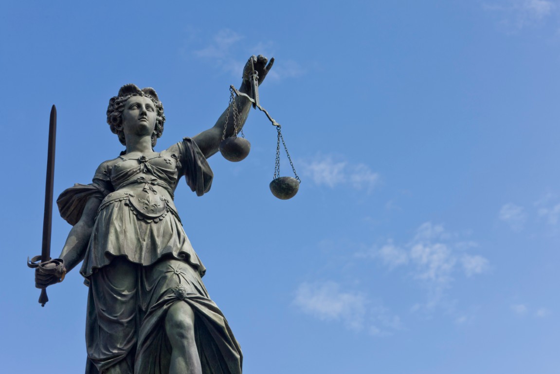 A statue of Lady Justice under a blue sky