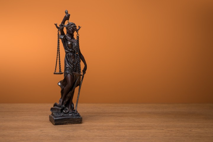 Bronze statue of the lady justice standing on a desk