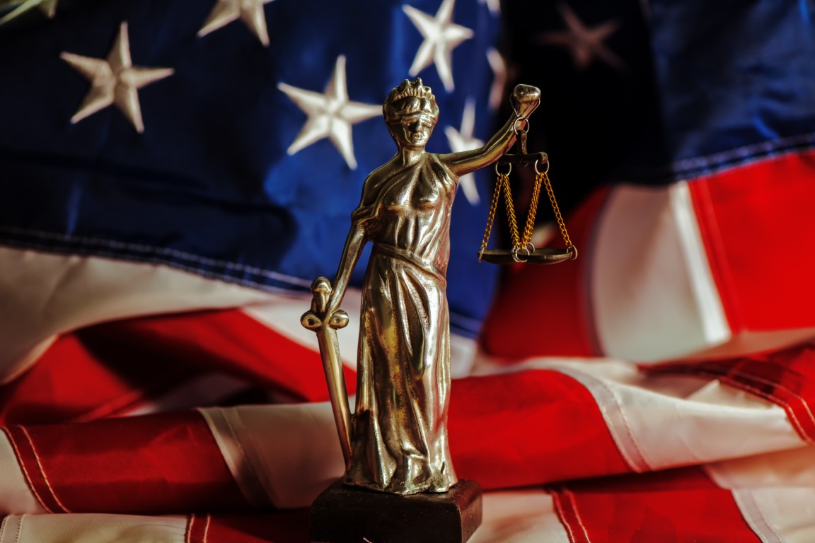 A statuette of Lady Justice on a U.S. flag