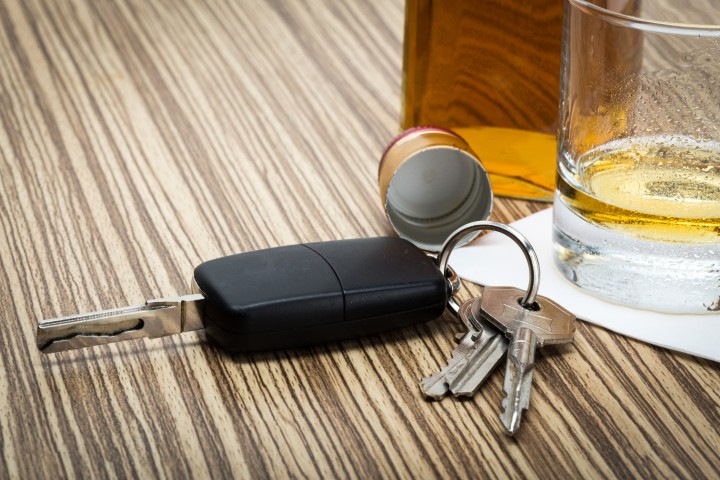 A glass of alcohol with a set of keys on a table