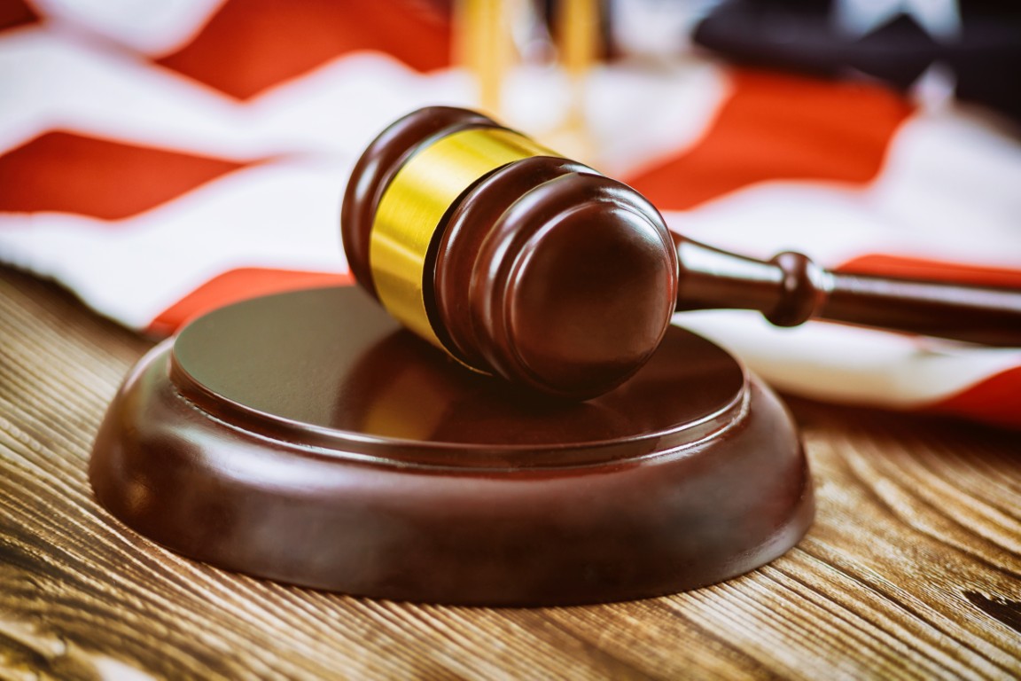 A judge's gavel in front of an American flag