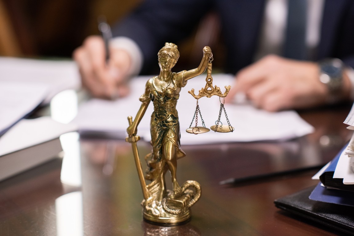 A statuette of Lady Justice on a lawyer's desk