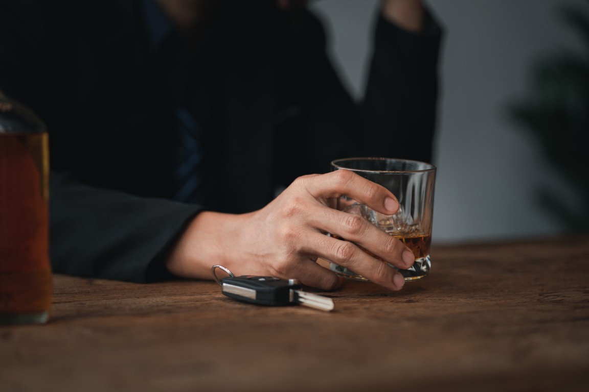 A man drinking at a bar with a set of car keys next to his drink